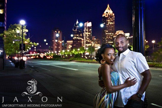 Couple on 17st in Atlantic Station with midtown Atlanta as a backdrop at nighttime at the end of their Engagement session