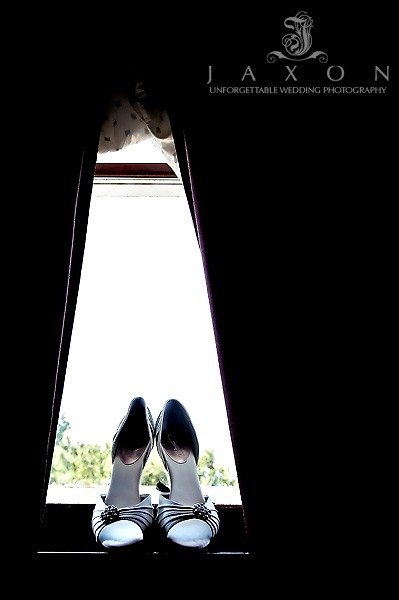 Brides shoes sits on window sill framed by the heavy curtains in the Bridal suite at Eagles Landing Country Club