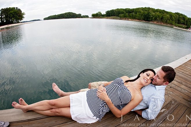 Couple lies on docks at LAke Lanier Islands Resort during their engagement session