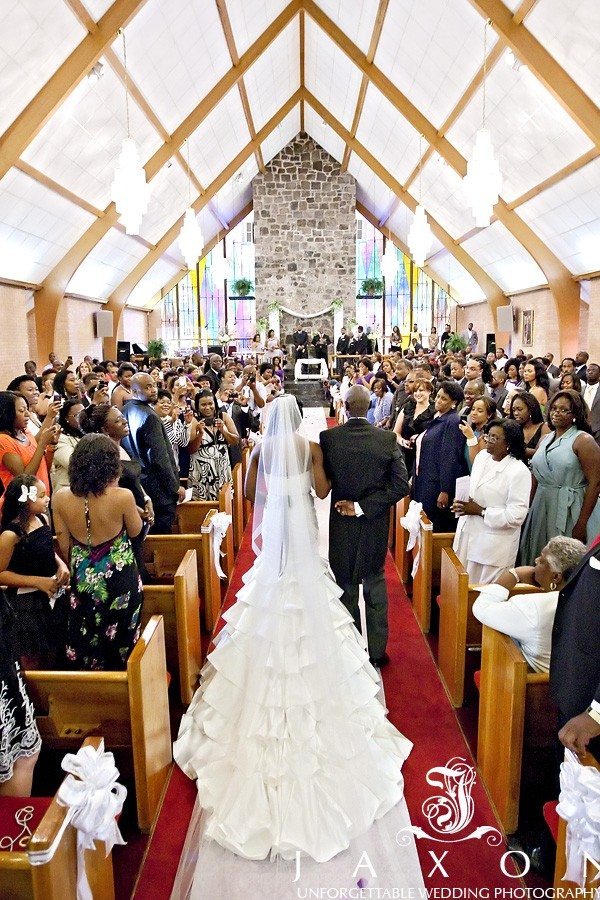 Bride's father escorts her into the wedding ceremony at Greater Community COGIC in Marietta | Olde Towne Club Wedding