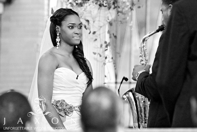 Bride listens intently as groom serenades her on his sax their wedding ceremony at Greater Community COGIC in Marietta | Olde Towne Club Wedding