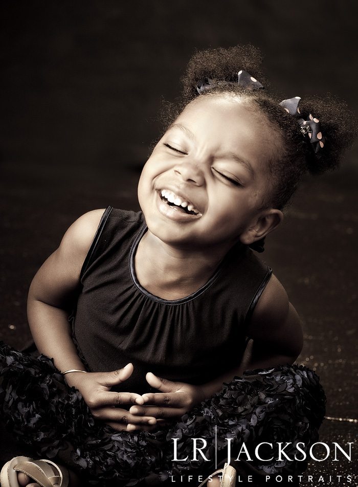 This 3 year old enjoys a laugh during her family portrait session