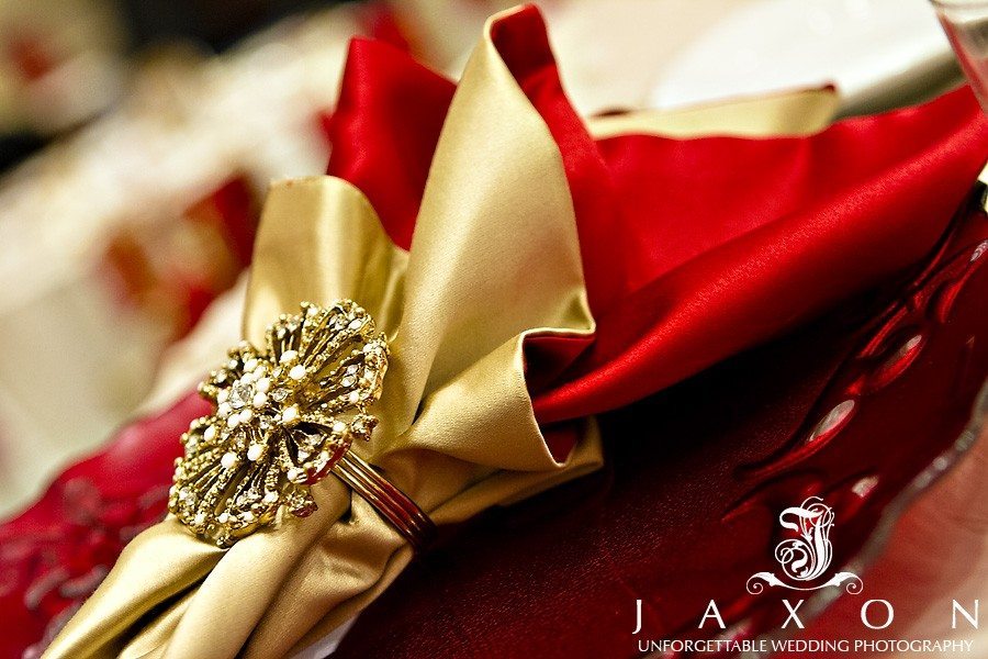 Red and gold napkin with gold napkin holder on clear charger | marriott gateway weddings