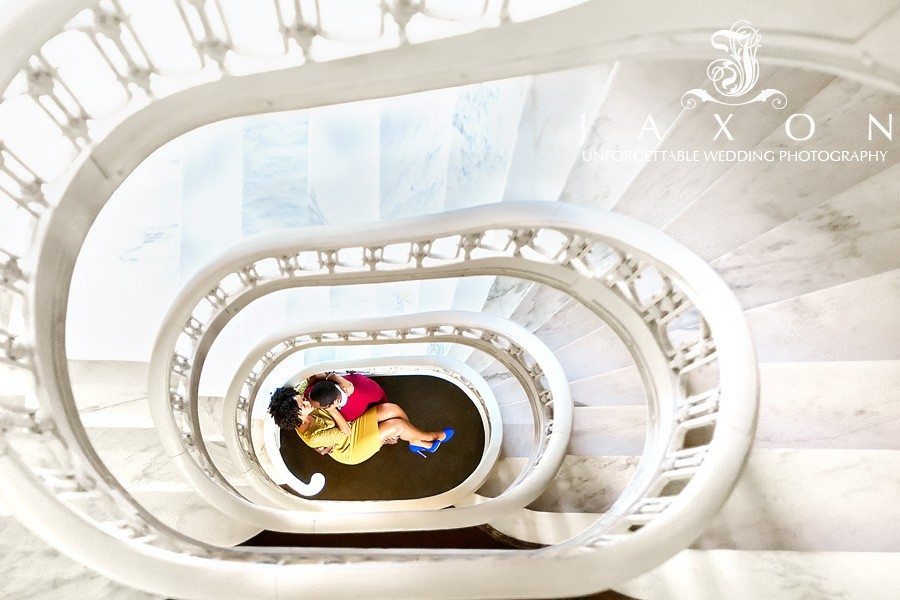 he sweeps her up in his arms at the bottom of the spiral staircase during their Georgian Terrace Hotel engagement session