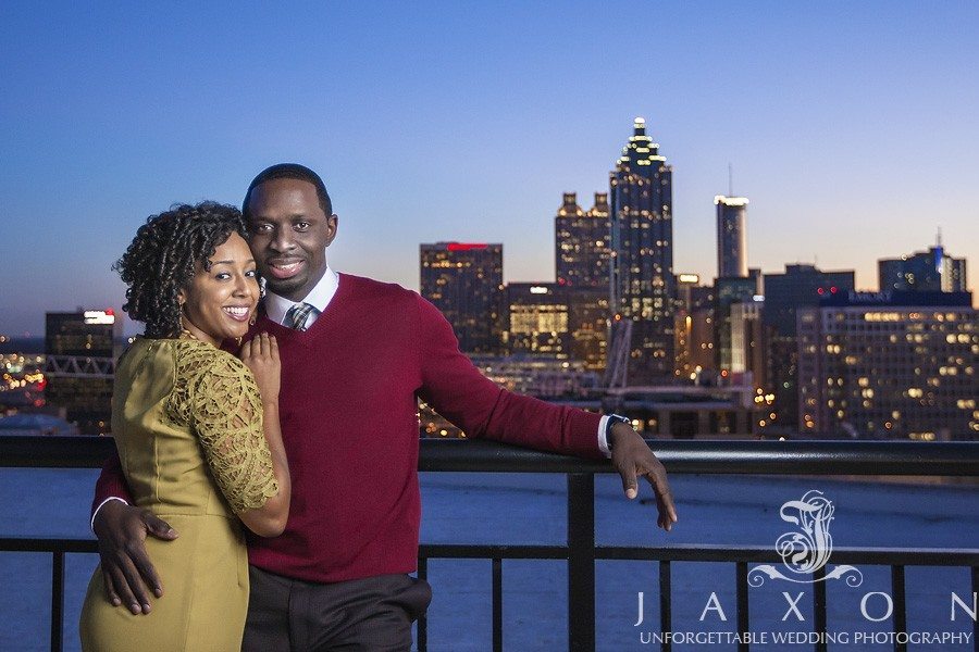 a roof top twilight portrait with the last embers of sunlight kissing the downtown Atlanta buildings in the background during their Georgian Terrace Hotel engagement session