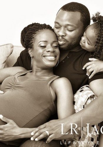 Husband, daughter and expecting mother in family portrait, sepia toned image of African American Family