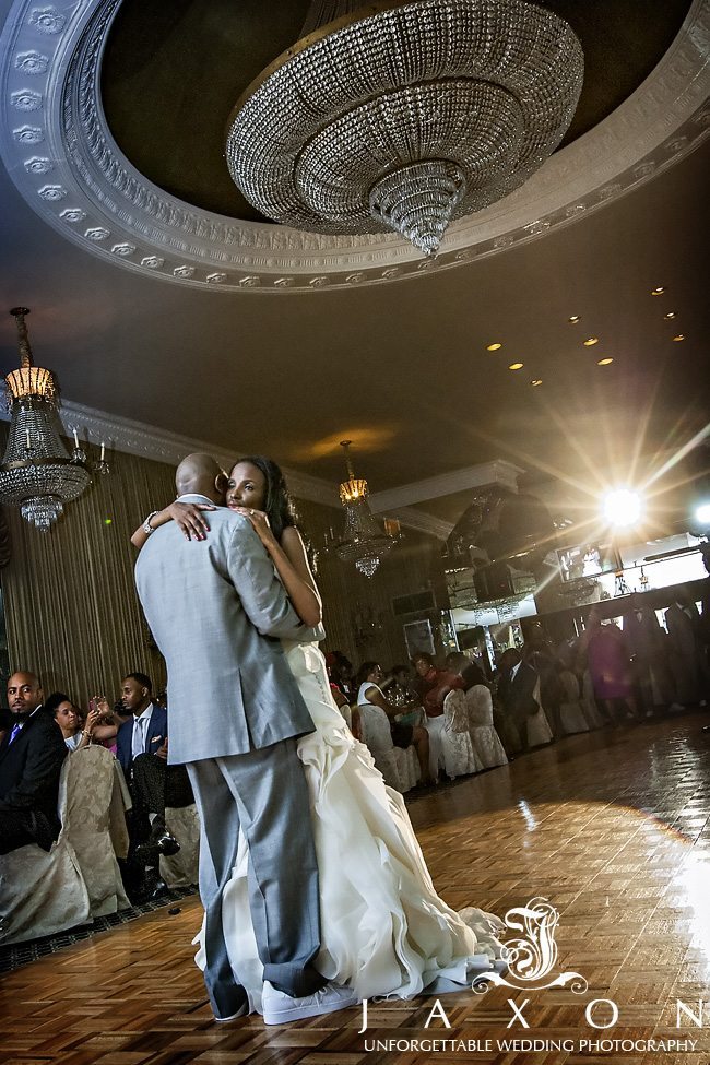 Bride and groom dances for the first time as husband and wife under the impressive chandelier | Riviera Wedding Brooklyn, NY