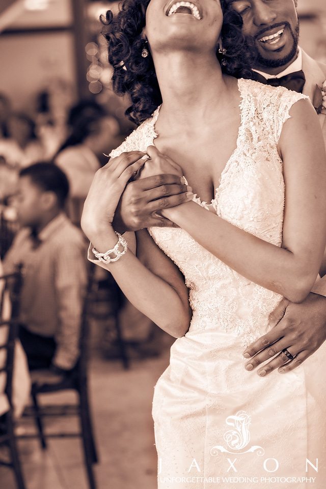 Sepia toned picture of bride and groom wrapped in each others embrace as they dance