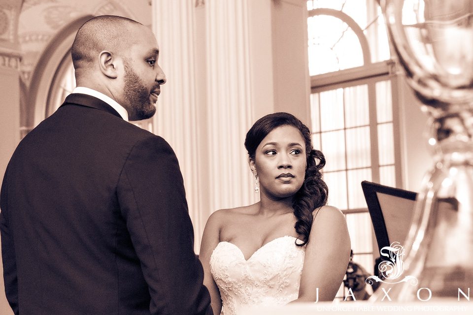 Sepia portrait of couple looking at minister as he recites their wedding vows in the Georgian Ballroom at the Biltmore Ballrooms Atlanta