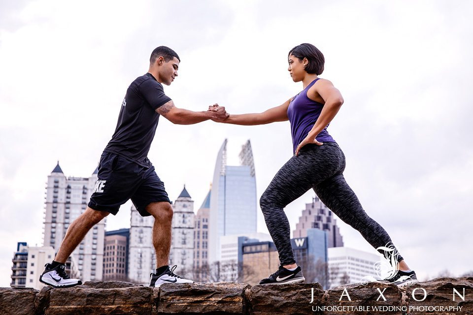 Couple in exercise gear working out at Piedmont Park with the midtown Atlanta skyline in background