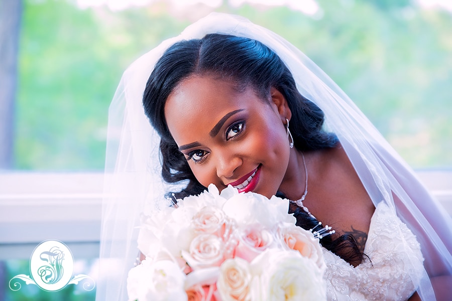 Portrait of bride with bouquet comprising of Peonies, Mother of Pearl and Sahara Roses.