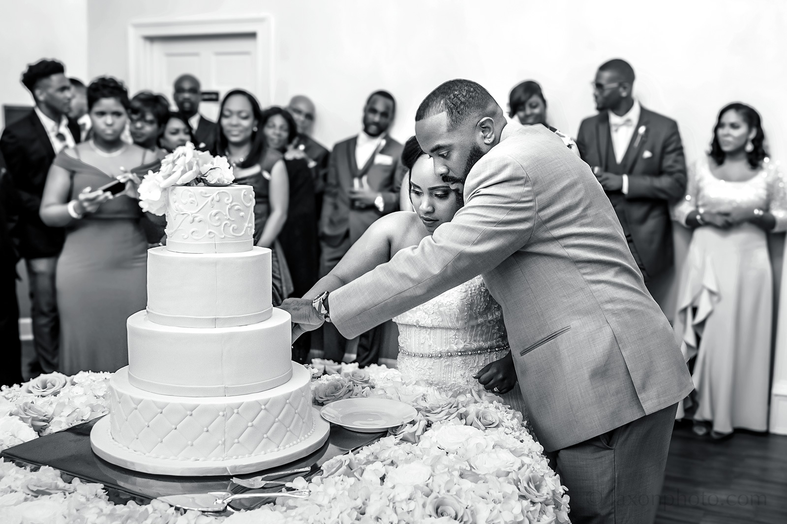 Cutting round four tiered wedding cake