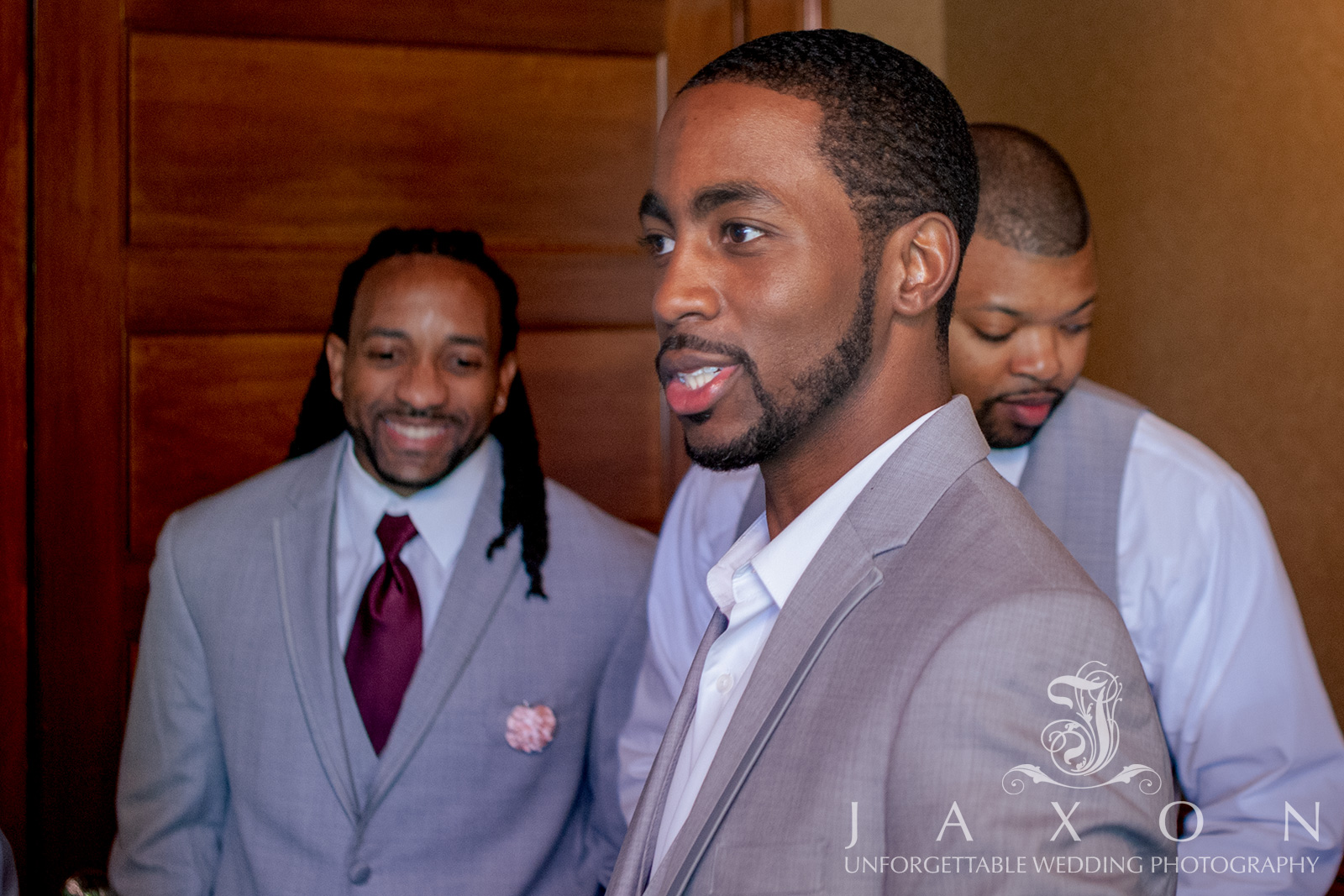 Sepia-toned portrait of groom and groomsmen preparing in the groom's suite for a wedding at Carl House.