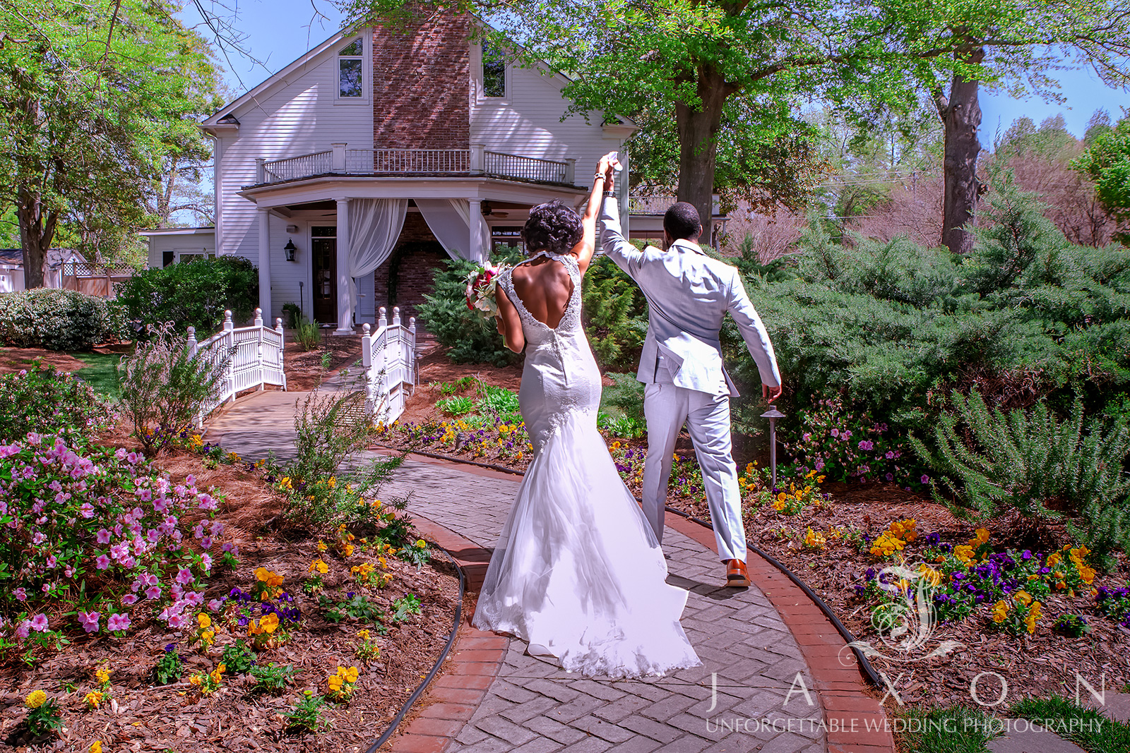 Bride and groom raising hands in celebration as they exit their wedding ceremony at Carl House, Auburn, GA.