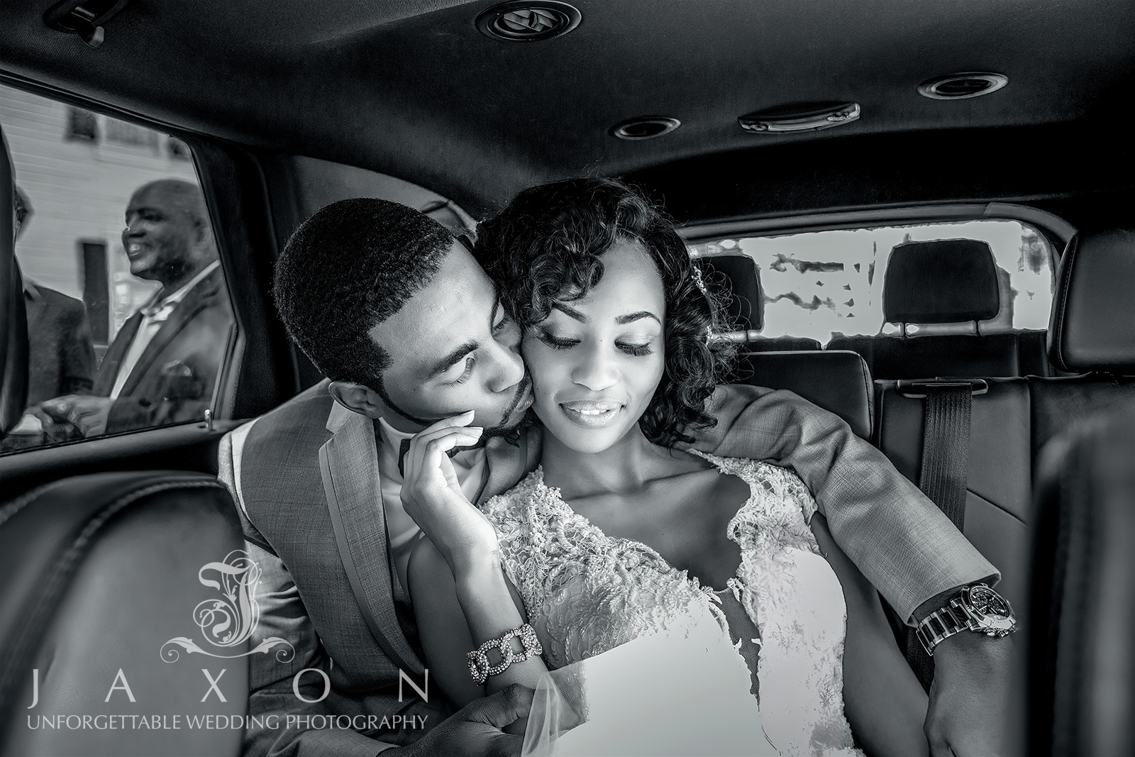 Newly married couple embracing in sepia-toned limousine, end of wedding day.