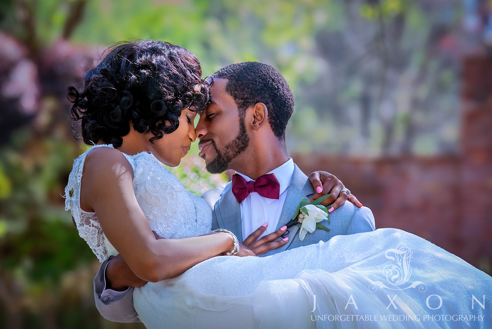 A romantic moment captured as the groom holds the bride in a garden setting at Carl House, Auburn, GA.